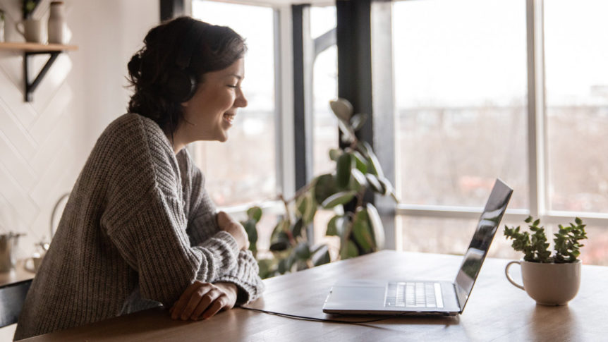 A person smiling to a laptop screen.