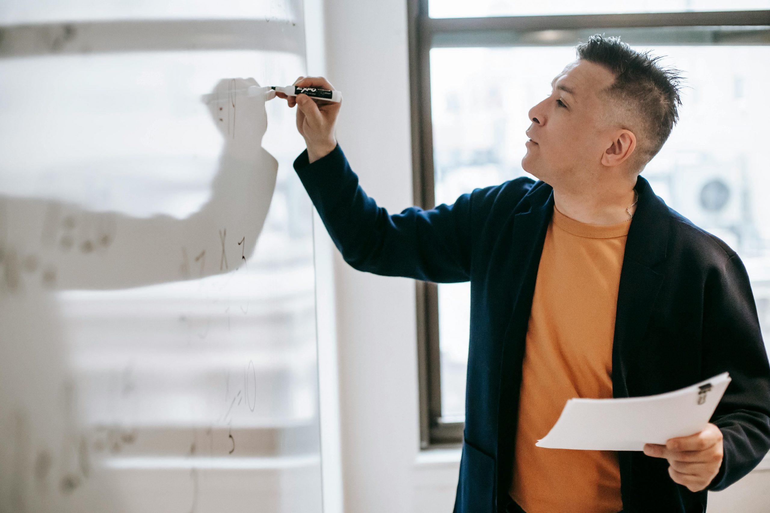 An instructor writing on a whiteboard.